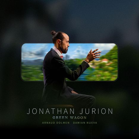 "JONATHAN JURION, GREEN WAGON, ARNAUD DOLMEN, DAMIAN NUEVA." Mann im Anzug sitzt seitlich, Hintergrund zeigt unscharfe Natur.