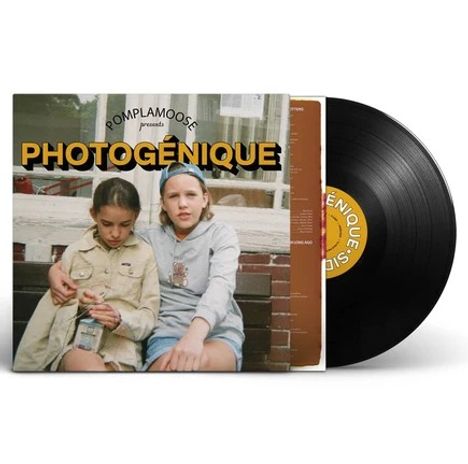 "PHOTOGÉNIQUE" in großen gelben Buchstaben; darunter sitzen zwei Kinder auf einer Treppe, das eine hält eine Flasche.