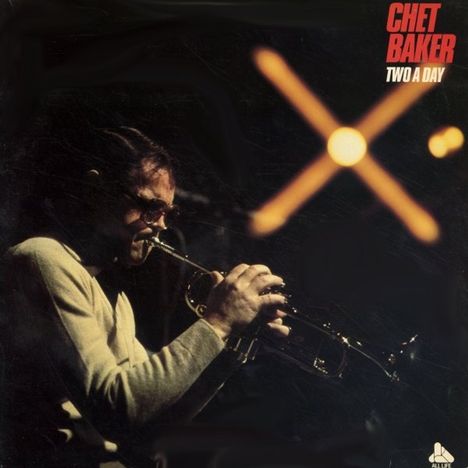 Oberer Text: "CHET BAKER TWO A DAY". Ein Musiker spielt Trompete im gedämpften Licht, mit unscharfem, hellem Hintergrund.