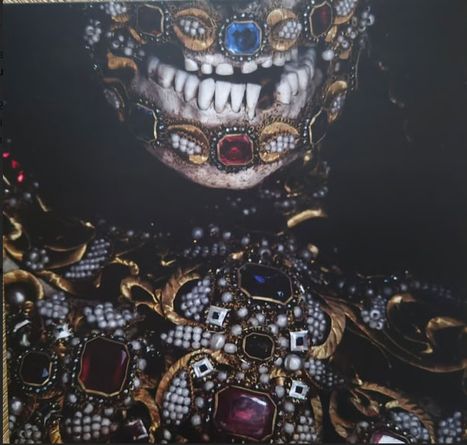 Ein Schädel, verziert mit Juwelen und Goldornamenten, zeigt Zähne und Edelsteine verschiedener Farben.
