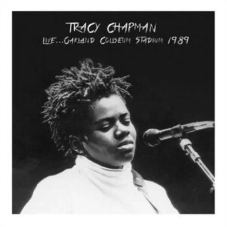 "TRACY CHAPMAN LIVE... OAKLAND COLISEUM STADIUM 1989." Eine Frau mit geschlossenen Augen singt in ein Mikrofon.