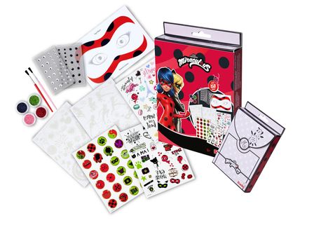 "Miraculous" und "150" auf einer Verpackung; Illustrationen von Figuren, Masken, Stickern, Glitzer und Pinseln.