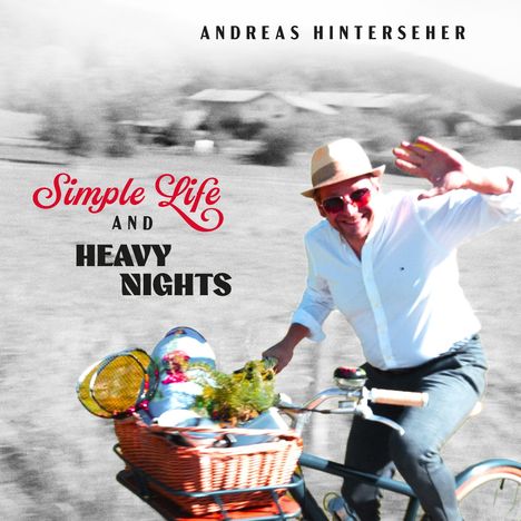Text: "Simple Life and Heavy Nights", "Andreas Hinterseher".   
Ein Mann mit Hut winkt auf einem Fahrrad mit Korb.