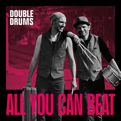 "DOUBLE DRUMS" und "ALL YOU CAN BEAT" stehen auf einem schwarz-roten Bild. Zwei Männer tragen Westen und halten Trommelstöcke.