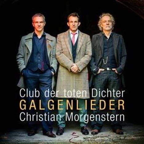 „Club der toten Dichter - GALGENLIEDER - Christian Morgenstern“. Drei Männer in Mänteln stehen nebeneinander.