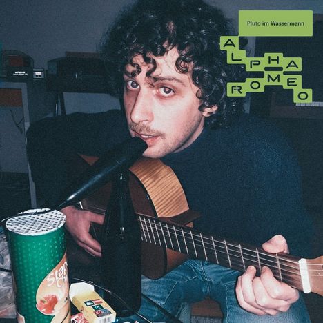 Texte: "Pluto im Wassermann", "Alpha Romeo". Ein Mann spielt Gitarre und singt ins Mikrofon; vor ihm Snacks und Getränke.