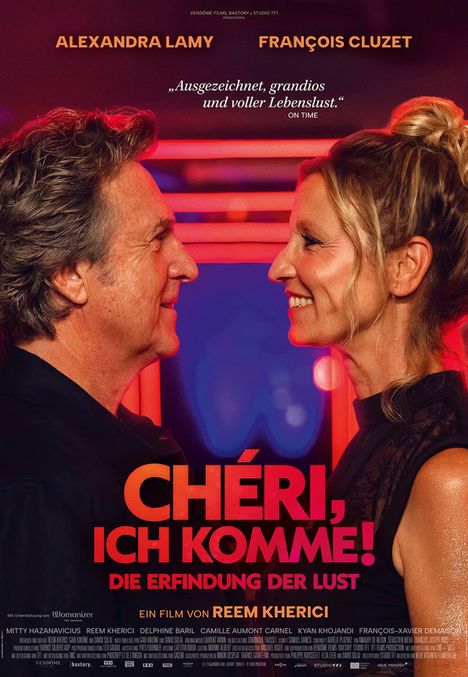 „CHÉRI, ICH KOMME! Die Erfindung der Lust.“ Zwei lächelnde Personen stehen sich nah gegenüber.