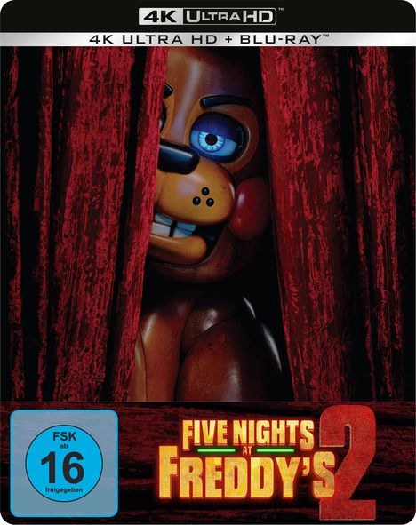 „4K Ultra HD + Blu-ray“, „Five Nights at Freddy's 2“, „FSK ab 16“. Ein animatronischer Bär schaut hinter roten Vorhängen hervor.