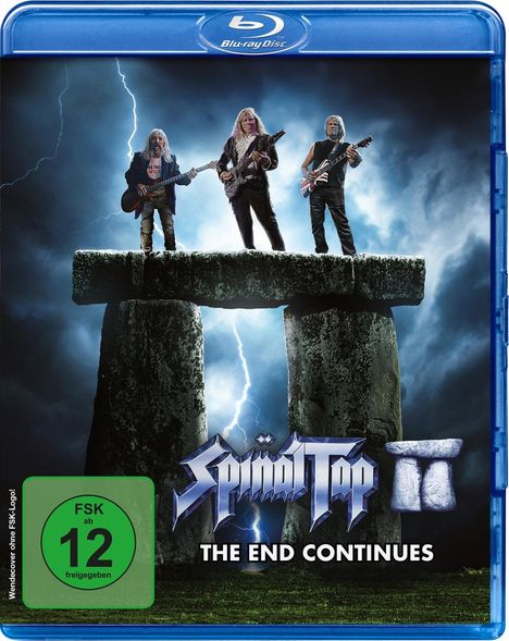 "Spinal Tap II: The End Continues", FSK ab 12. Drei Musiker mit Gitarren stehen auf einem monumentalen Stein, umgeben von Blitzen.
