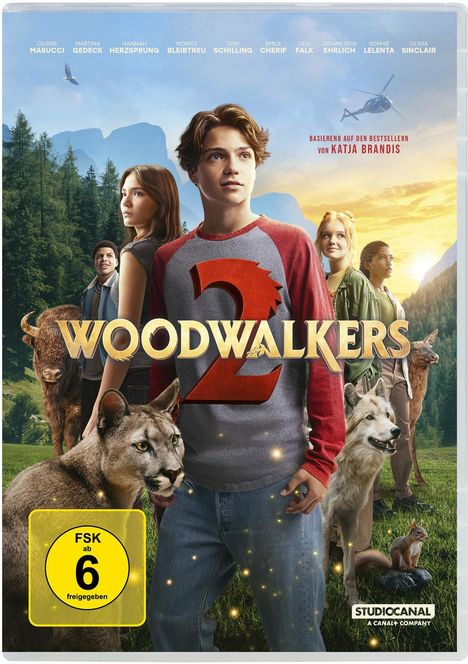 „WOODWALKERS 2“, FSK 6, Namen von Schauspielern, Landschaft mit Bergen und Tieren, junge Menschen im Vordergrund.