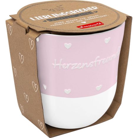 "Herzensfreundin" steht auf einem rosa-weißen Becher, umgeben von einer Verpackung mit weißen Herzen.