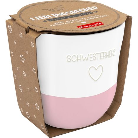 Tasse mit Text "SCHWESTERHERZ" und Herzsymbol, in rosa-weißem Design. Verpackung aus Karton mit Blumenmuster und "LIEBLINGSBECHER".