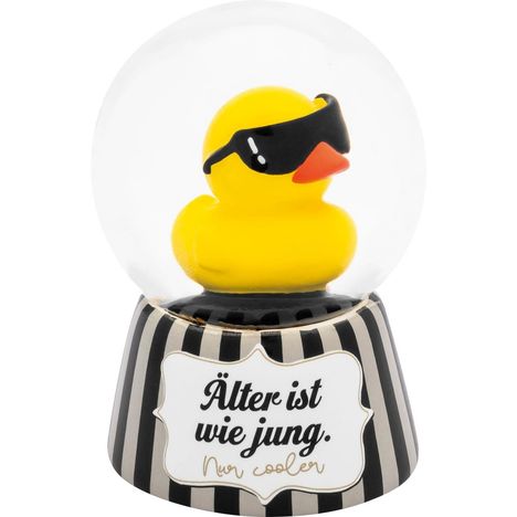 "Älter ist wie jung. Nur cooler" steht auf einem Sockel. Eine gelbe Gummiente mit Sonnenbrille ist in einer Glaskugel.
