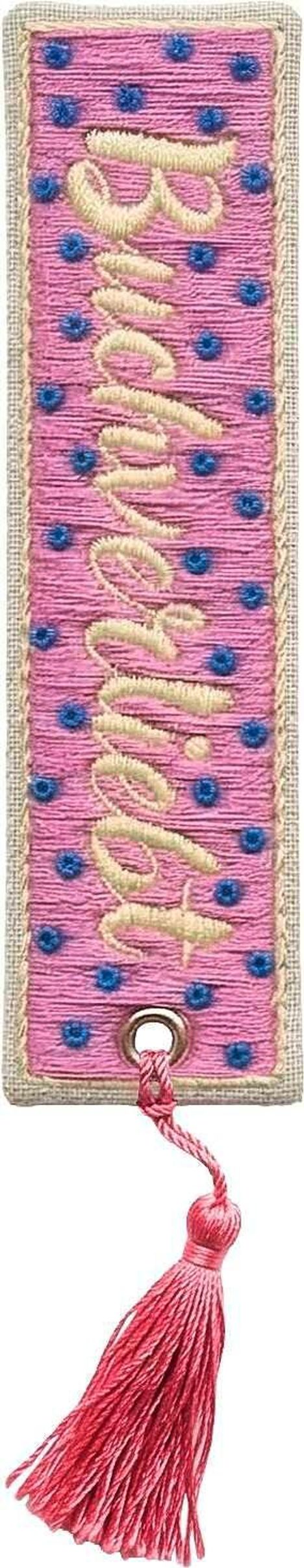 Der Stickerei-Text lautet "Autumn". Rosa Lesezeichen mit blauen Punkten und beige Stickerei, unten rosa Quaste.