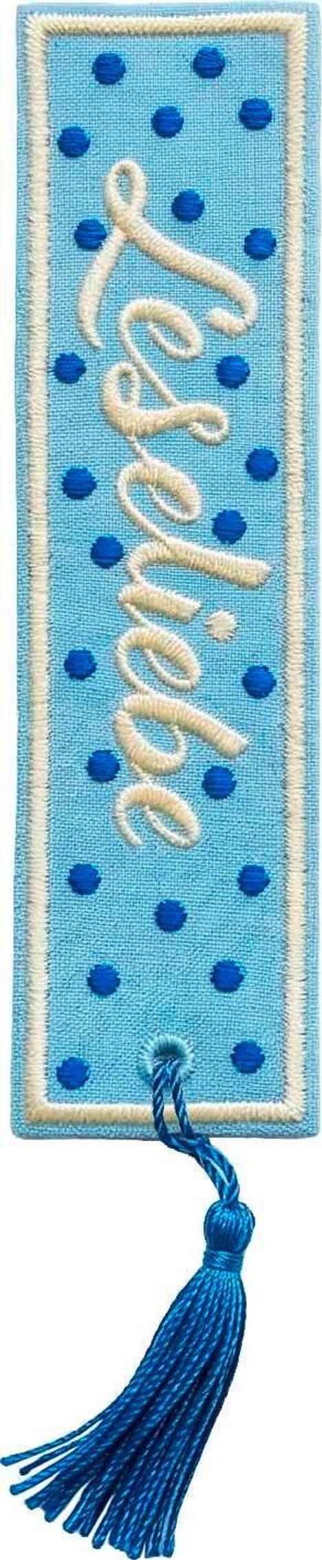 Das Wort "Inspire" in geschwungener Schrift. Hellblaues Lesezeichen mit dunkelblauen Punkten und Quaste.