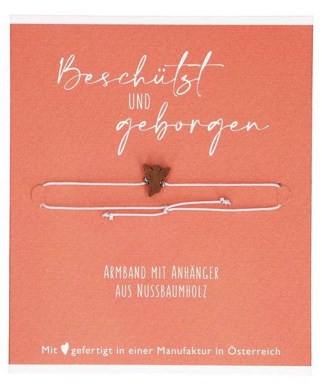 "Beschützt und geborgen", "Armband mit Anhänger aus Nussbaumholz", "Mit ❤️ gefertigt in einer Manufaktur in Österreich". Weiße Schnur mit Holzanhänger auf orangefarbenem Hintergrund.