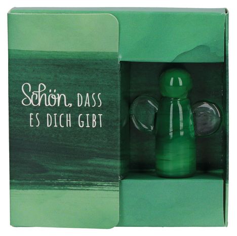 Text: "Schön, dass es dich gibt." Ein kleiner grüner Glasengel in einer Verpackung mit grünem Design.