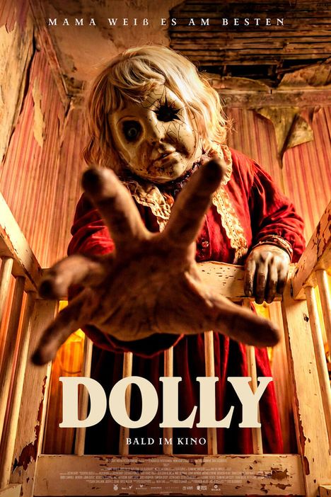 Text: "MAMA WEISS ES AM BESTEN", "DOLLY", "BALD IM KINO". Eine gruselige Puppe in einem spärlich beleuchteten Raum.