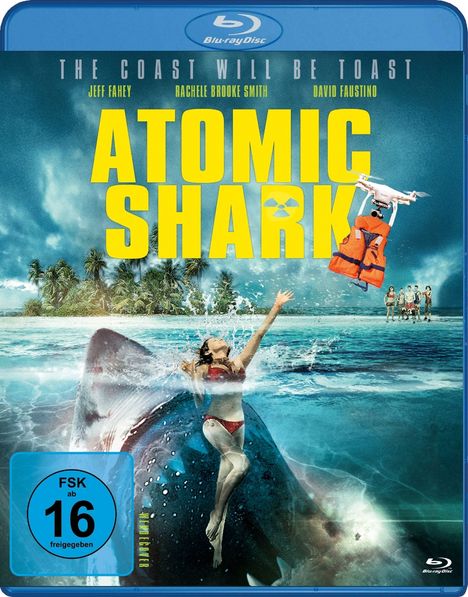 "Atomic Shark" ist in großen gelben Buchstaben über einer Frau auf einem Hai, umgeben von Wasser und tropischen Bäumen.