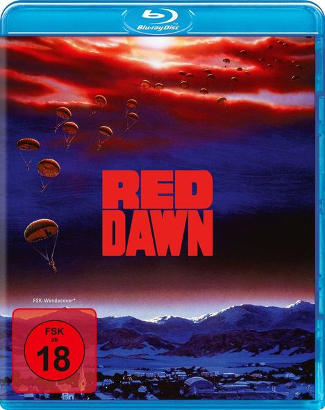 "RED DAWN" in roten Buchstaben, Fallschirmspringer am Himmel, Berglandschaft und Stadt im Hintergrund, FSK 18.