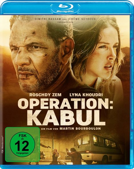 Roschdy Zem und Lyna Khoudri in "Operation: Kabul", ein Film von Martin Bourboulon. Staubige Szene mit zwei Menschen.