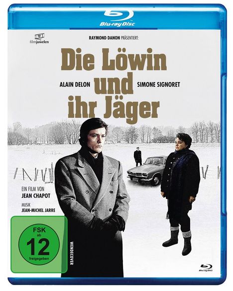 Titel: "Die Löwin und ihr Jäger". Darunter Alain Delon, Simone Signoret. Zwei Personen im Wintermantel vor einem Auto im Schnee.