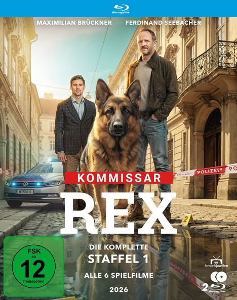 Text: "Maximilian Brückner, Ferdinand Seebacher, Kommissar Rex, Staffel 1, Alle 6 Spielfilme, 2026, FSK ab 12."

Beschreibung: Zwei Männer stehen auf einer Straße mit einem Schäferhund. Polizeiband und Auto im Hintergrund.