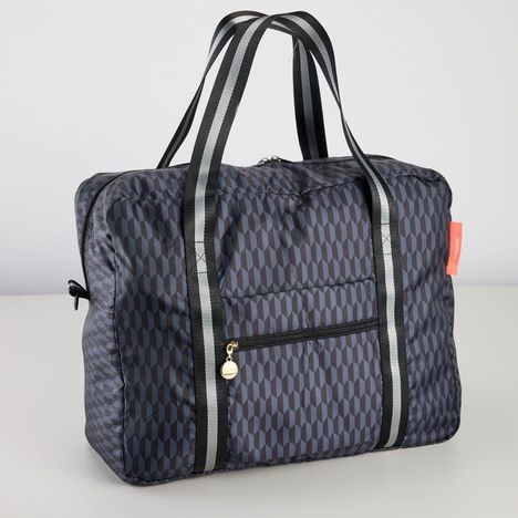 Rotes Etikett mit "LOQI". Dunkelblaue Tasche mit schwarz-weißen Streifen und geometrischem Muster.