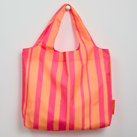 Ein pink-orange gestreifter Stoffbeutel mit einem Etikett, auf dem "Géon" steht.