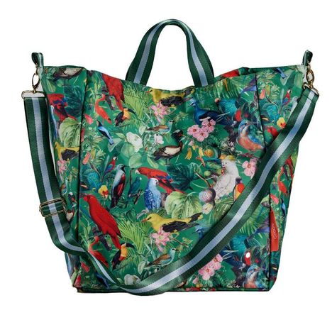 Aufschrift "COCON". Eine bunte Tasche mit Papageien und Tropenmuster, zwei grünen Tragegriffen und einem gestreiften Schultergurt.