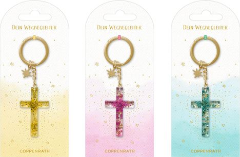 Anhänger mit der Aufschrift "Dein Wegbegleiter" und "COPPENRATH". Drei Schlüsselanhänger mit Kreuz in Gold, Lila und Grün.