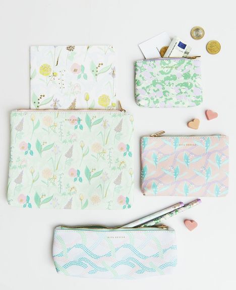 Verschiedene bunte Taschen mit Blumenmustern und Schriftzug "Rico Design", daneben Münzen und Herzformen.