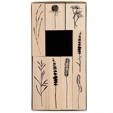 Holzstempel mit schwarzen Pflanzenmotiven in einem rechteckigen Set arrangiert.