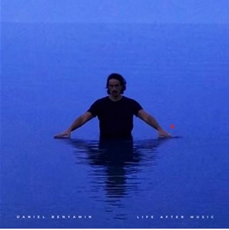 "Daniel Benyamin - Life After Music" unten. Ein Mann steht im blauen Wasser, Arme ausgestreckt, dunkle Kleidung.