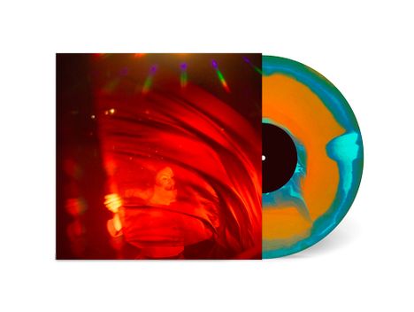 Ein Mann in rotem Lichtschein und Nebel. Vinyl in Orange und Blau mit schwarzem Zentrum. Erscheinung von Bewegung und Farben.