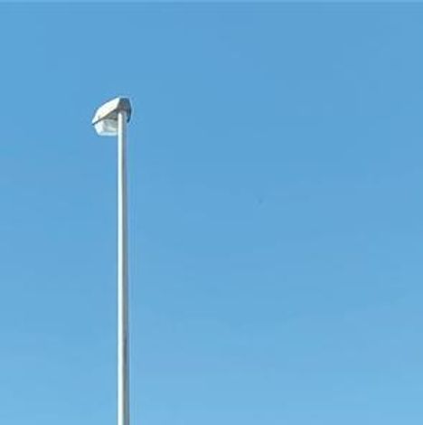 Einzelne Straßenlaterne ragt in den klaren blauen Himmel.