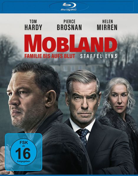 Die Worte "Tom Hardy, Pierce Brosnan, Helen Mirren", "Mobland", "Familie bis aufs Blut", "Staffel Eins". Darunter drei ernst blickende Personen. Links ein Mann im Profil, mittig ein Mann im Anzug, rechts eine Frau mit grauem Haar.