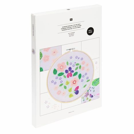 "Diamond Painting / DIY-Set Bild" und "Incl. Ring" oben auf einem Karton; Blumenmuster im Stickrahmen, pastellige Farben.