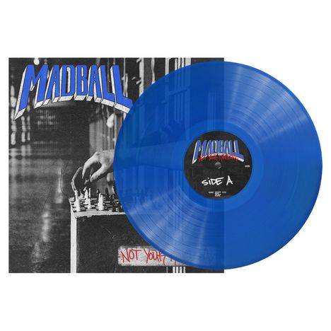 „MADBALL“ und „Side A“ sind in großen Buchstaben zu sehen. Eine blaue Vinyl-Schallplatte liegt teils auf einem Cover.