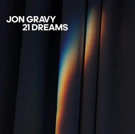 Text: "JON GRAVY 21 DREAMS". Vertikale Vorhänge mit einem schimmernden, regenbogenfarbenen Lichteffekt.
