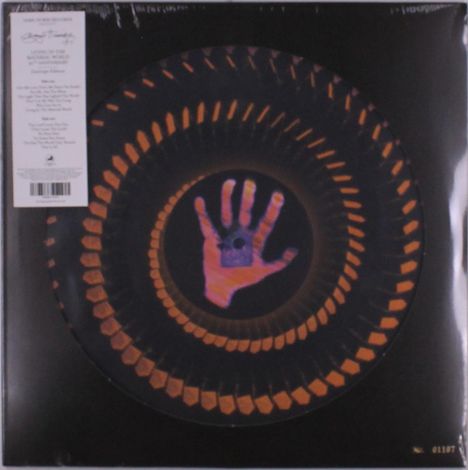 "Living in the Material World," Europe Edition. Eine Illustration zeigt eine Spirale mit einer Hand im Zentrum.