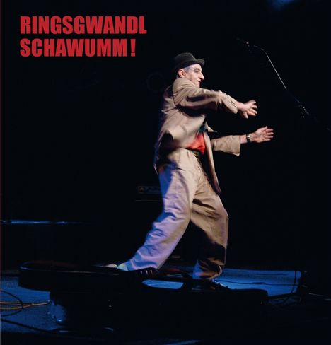 Text: "RINGSGWANDL SCHAWUMM!" Ein Mann in Anzug und Hut tanzt auf einer Bühne mit Mikrofon.