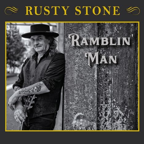 Oben steht "Rusty Stone" in Gelb, daneben ein stilisiertes Symbol. Rechts "Ramblin' Man". Ein Mann lehnt an einer Wand.