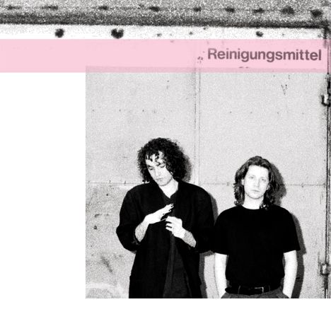 Text: "Reinigungsmittel". Zwei Personen stehen nebeneinander vor einer Metallwand. Bearbeitetes Schwarz-Weiß-Foto.