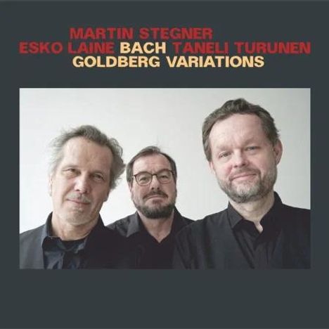 MARTIN STEGNER, ESKO LAINE, BACH, TANELI TURUNEN in farbigen Lettern. Drei Männer in schwarzen Hemden posieren.
