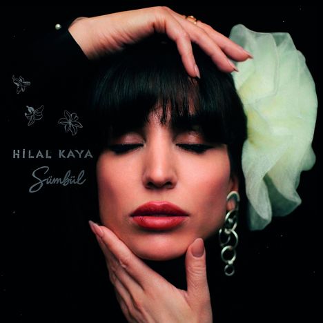 „Hilal Kaya, Sümbül“ steht in geschwungener Schrift. Ein Porträt einer Frau mit geschlossenen Augen und Blume im Haar.