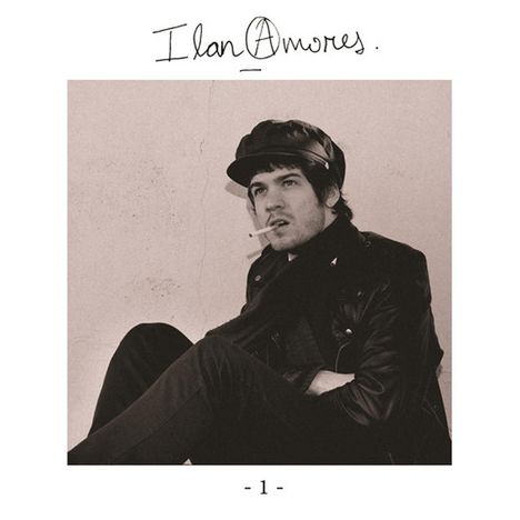 „Ilan Amores“ steht oben, „- 1 -“ unten. Schwarz-weiß Porträt eines Mannes mit Mütze und Zigarette, Lederjacke.