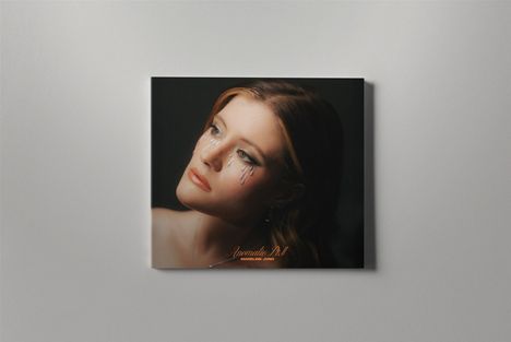 "Anomalie Pt. II MADLINE JUNO". Eine Frau schaut seitlich nach oben, mit Glitzertränen auf den Wangen.