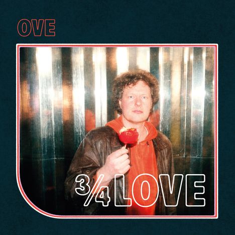 „OVE 3/4 LOVE“ - Ein Mann hält einen angebissenen roten Apfel vor glänzendem Hintergrund.