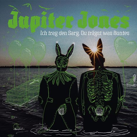 "Jupiter Jones, Ich trag den Sarg, Du trägst was Buntes." Zwei Figuren mit Tiermasken stehen vor einem Wasserhintergrund.